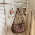 Close-up of quilted coffee hobo bag with zip pocket hanging in a minimal home setting - Coffee