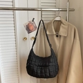 Close-up of black quilted nylon crescent shoulder bag featuring a puffy lattice texture - Black