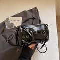 Dettaglio della borsa a cilindro nera stile punk con cerniere in argento e pelle lucida - Nero