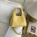 Dettaglio macro della borsa gialla in pelle martellata con hardware dorato e cinturino - Giallo