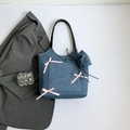 Dunkelblaue Denim-Tragetasche mit drei rosa Seidenschleifen und schwarzen Ledergriffen - Dunkelblau