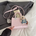 Borsa a tracolla rosa chiaro minimalista con manico intrecciato e ciondolo orsetto - Rosa