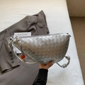 Silberne gewebte Halbmond-Handtasche mit Metallic-Finish und orangefarbenem Anhänger - Silber