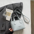 Elegant light blue mini bucket bag in pebble leather finish with gold logo and shoulder strap - Blue Without Charm