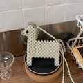 Detalle de un bolso bandolera con forma de poni hecho a mano con perlas blancas tejidas - Plata Grande