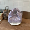 Detail einer lavendelfarbenen Seidenbrokat-Handtasche mit Pflaumenblüten auf Keramik - Lila
