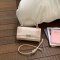 Detail der cremefarbenen Handtasche mit Kroko-Prägung und silbernem Drehverschluss - Weiß & Rosa