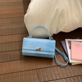 Détail d'un sac à main bleu clair à motif crocodile avec fermoir pivotant en métal argenté - Bleu