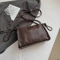 Detail of dark brown leather shoulder bag featuring adjustable knotted strap and silver buckle - Brown