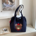 Dettaglio ravvicinato della borsa tote in tela blu con ricamo Party Bear squisito - Blu Notte