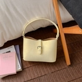 Dettaglio della borsa a spalla vintage crema con texture in pelle e fibbia in metallo argento - Vestibilità regolare / Giallo