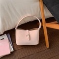 Dettaglio borsa a secchiello rosa chiaro con trama a pieghe e fibbia argento sul pavimento - Vestibilità regolare / Rosa