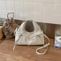 Detalle del bolso nube plisado en piel suave con lazos elegantes y correa ajustable - Gris claro