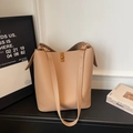 Détail du sac seau en cuir grainé avec boucle en métal doré et bandoulière réglable - Abricot