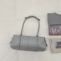 Dettaglio della borsa tote in pelle grigio chiaro con forma cilindrica e parte superiore pieghettata - Blu