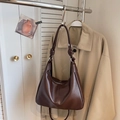 Dettaglio di una borsa hobo marrone scuro con dettagli decorativi a nodo sulla tracolla - Marrone
