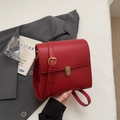 Detail der roten Vintage-Umhängetasche mit Goldschnalle auf weißem Stoffhintergrund - Rot