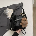Classic black bucket bag in premium PU leather featuring a silver metal clasp and puppy charm - Black with Pendant