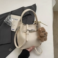 Creamy white PU leather bucket bag with silver lock and a cute brown bear charm - Cream White With Pendant