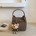 Detailansicht der braunen Bucket-Bag aus Leder mit Litschi-Maserung und Bärenanhänger - Khaki mit Anhänger