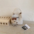 Detail der Bucket Bag aus Leder mit Litschistruktur, Schnalle und Bärenanhänger - Weiß mit Anhänger