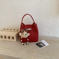 Detail der roten Eimer-Tasche aus Kieselleder mit silbernem Drehverschluss und Bär - Rot mit Anhänger