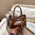 Borsa a tracolla marrone scuro con perle in legno e chiusura a girello in metallo - Marrone