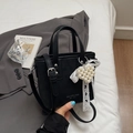 Chic black bucket bag with pearl heart pendant and lace bow detail on a casual backdrop - With Pendant / Black