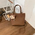 Gros plan sur le sac fourre-tout en cuir marron avec un joli pendentif en peluche - Café avec Pendentif