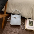 Detail view of the light blue bucket bag showing matte leather texture and metal swivel lock - No Pendant / Blue