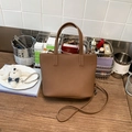 Brown faux leather tote bag with lychee texture on wooden table in a lifestyle setting - Brown No Pendant