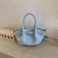 Detailed close-up of sky blue pleated bucket bag with metal buckle and leather texture - Blue Without Charm