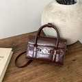 Detalle de bolso marrón oscuro con grabado de cocodrilo y hebilla de corazón plateada - Marrón