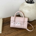 Detalle de bolso rosa con textura de cocodrilo y hebilla de corazón en mesa de madera - Rosa