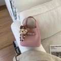 Detalle de bolso cubo rosa con textura de lichi, correa de hebilla y amuleto de oso de peluche - Rosa con colgante