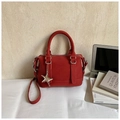 Borsa Boston rosso scuro minimalista con grana litchi e ciondolo a stella sulla scrivania - Rosso con Pendente