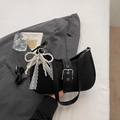 Detail of black nylon underarm bag with silver buckle strap and pearl lace bow charm - Black with Pendant