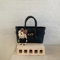 Detail of black pebbled leather tote bag with gold twist lock and cute bear charm - Black (With Pendant)