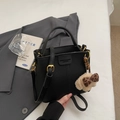 Elegante schwarze Eimer-Handtasche aus Leder mit Bärenanhänger und goldenen Metall-Beschlägen - Schwarz