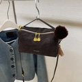 Minimalist dark brown litchi leather pillow bag with gold hardware and fur ball charm - Coffee