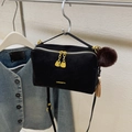 Minimalist black leather pillow bag with golden zippers and brown plush charm - Black