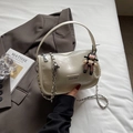 Detail van crème-witte leren handtas met zilveren ketting en een parel hanger - Beige Met Hanger