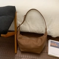 Detalle de bolso hobo de cuero caramelo con textura granulada y cremallera plateada - Marrón