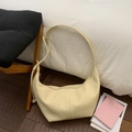 Detalle de bolso hobo beige crema con textura de cuero granulado y costuras precisas - Amarillo