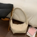 Detalle de bolso hobo de cuero crema con correa ajustable en una escena de hogar - Blanco