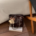 Détail du sac seau matelassé marron avec chaîne dorée et breloque ourson - Café avec Pendentif