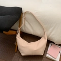 Detalle de la textura del cuero del bolso hobo beige y de la correa de hombro minimalista - Rosa