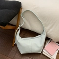 Detailed view of a light blue crescent hobo bag with pebble leather texture and a zipper closure - Blue