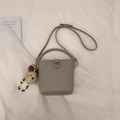 Détail du sac seau taupe avec cuir grainé et charmant pendentif en forme d'ours doux - Avec Pendentif / Gris