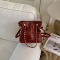 Detail of burgundy quilted leather bucket bag with gold chain handle on white sofa - Red (No Pendant)